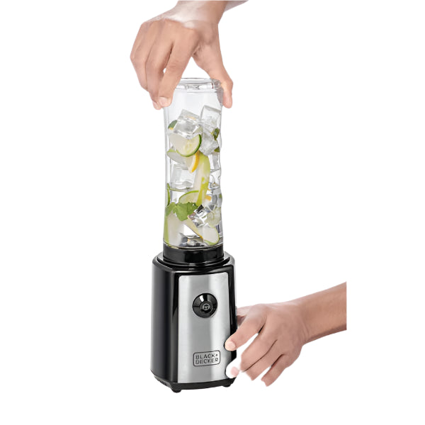 Hand holding a portable blender with ingredients inside on a white background