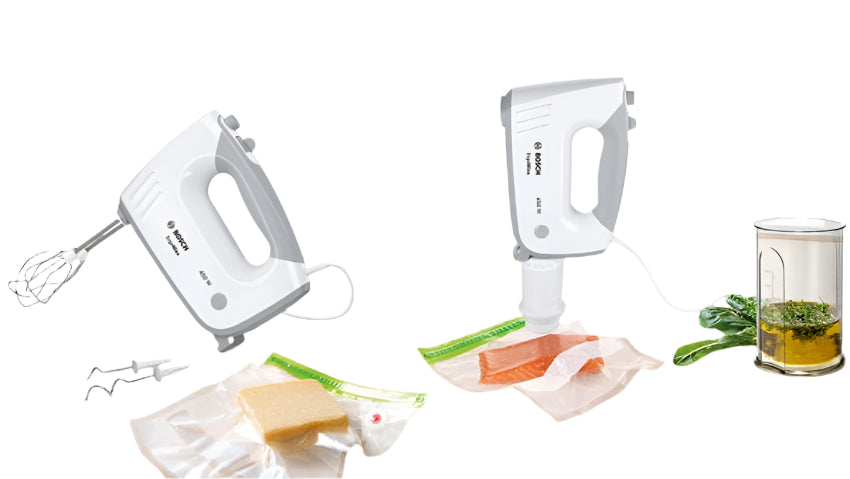 Two hand mixers on a wooden surface with ingredients and kitchen tools.