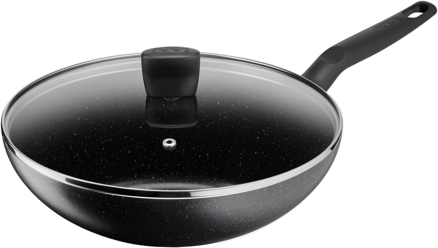 Black frying pan with glass lid on a white background