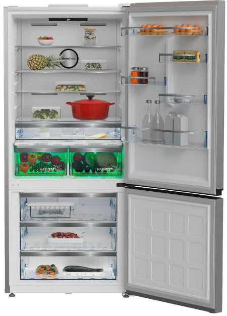 A side-by-side refrigerator with the upper door open, showing the interior shelves, door bins, and lower freezer drawer. The fridge is stocked with food and bottles, set against a plain white background.