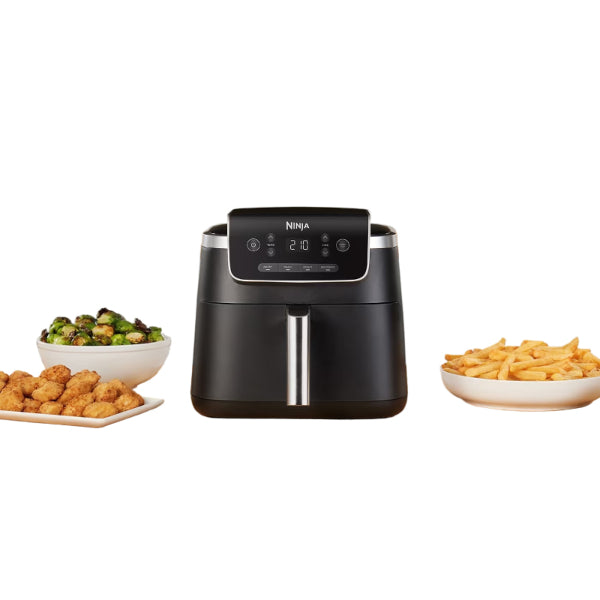 Ninja air fryer on a kitchen counter with various foods around it