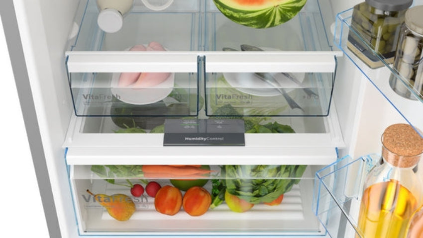 Open refrigerator with fresh produce and drinks on the shelves.