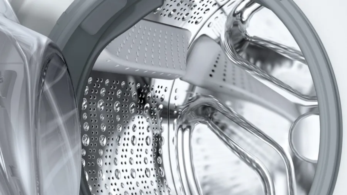 Close-up of a washing machine drum with water droplets