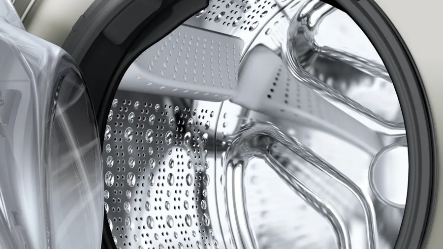 Close-up of a washing machine drum with water droplets inside