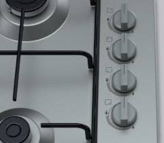 Close-up of a gas stove with control knobs on a white background