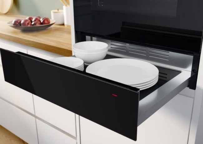 Modern kitchen with a built-in oven displaying plates inside