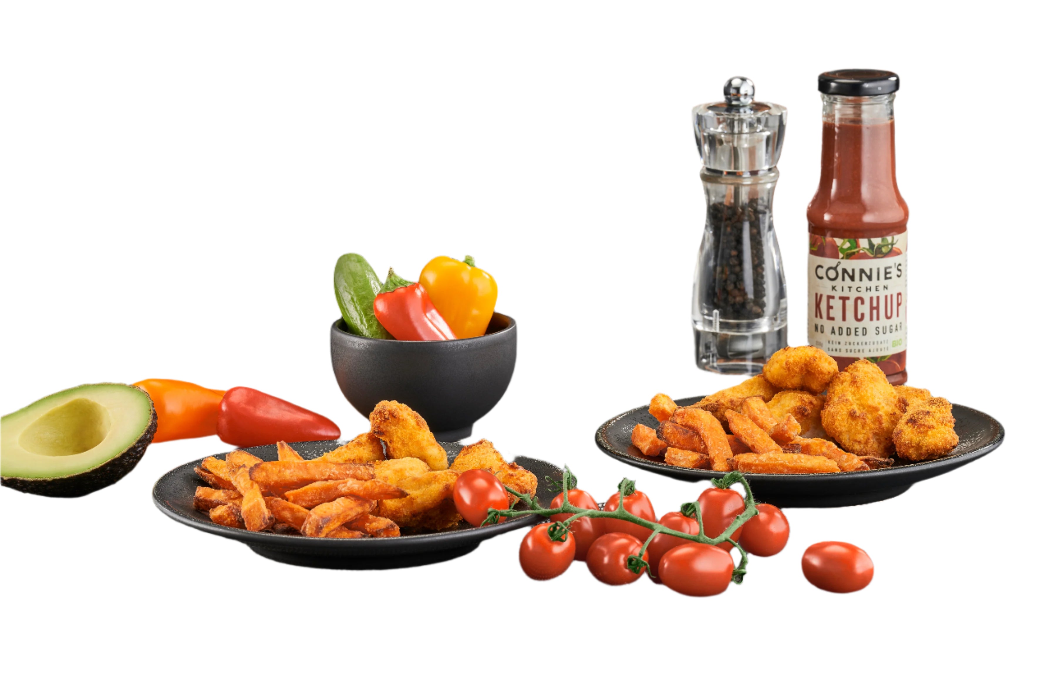 Black air fryer with plates of fried food, vegetables, and a bottle of ketchup on a gray surface.